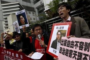 Pro-democracy demonstrators hold up portraits of Causeway Bay Books shareholder Lee Bo (R) during a protest to call for an investigation behind the disappearance of five staff members of a Hong Kong publishing house and bookstore, outside the Chinese liaison office in Hong Kong, China in this January 3, 2016 file photo. REUTERS/Tyrone Siu/File